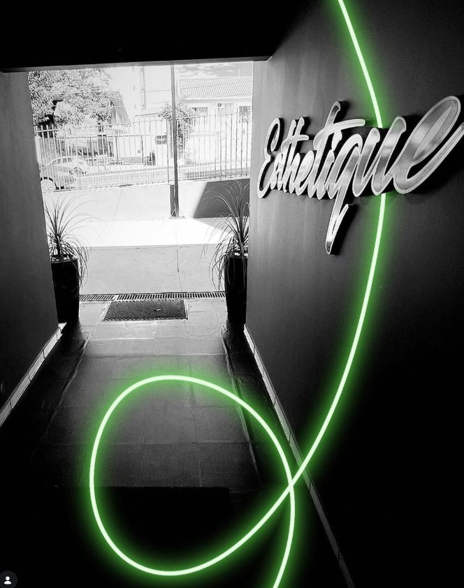 Entrada da Clínica Esthetiqué com o letreiro da marca e luz neon verde